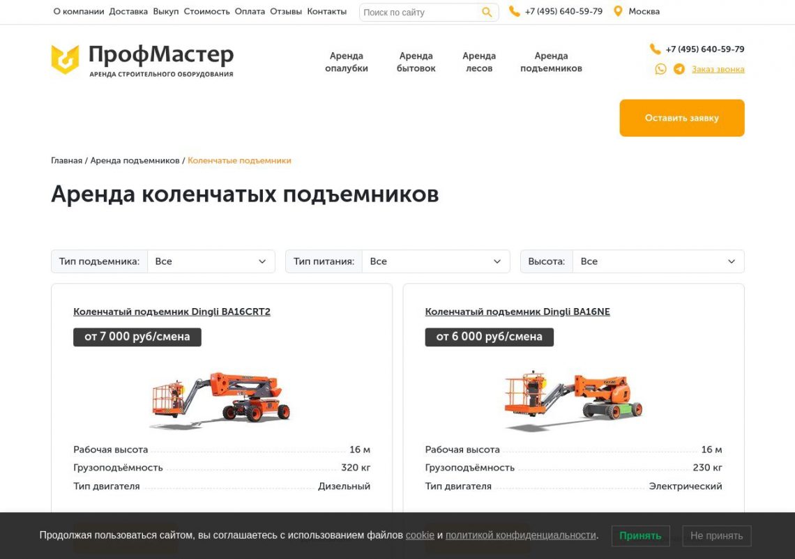 Группа инженеров в касках обсуждает технический план, стоя рядом с несколькими подъемниками на строительной площадке.